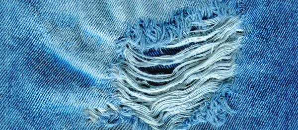 Hole and threads on denim jeans — Stock Photo, Image