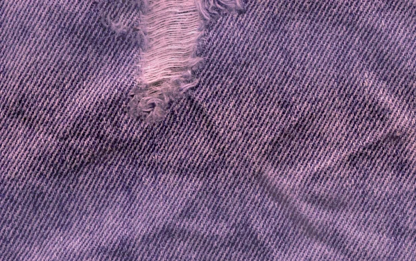 Джинсовая текстура синего цвета. Джинсы порваны текстурой ткани — стоковое фото