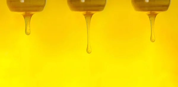 Honey flowing from a wooden honey spoon. Wide format banner — ストック写真