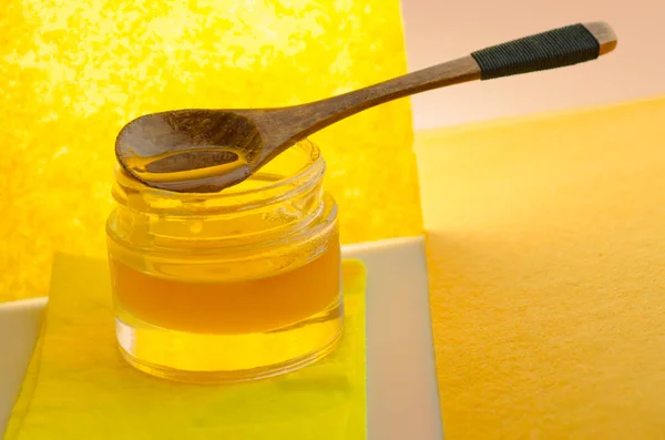 Medové sklo a dřevěná medová lžička. Sladká medová nádoba. — Stock fotografie