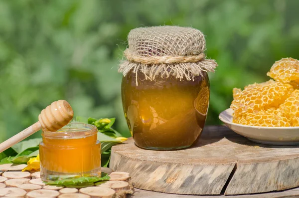 素朴な木製のテーブルの背景に蜂蜜ディッパーと瓶の蜂蜜 — ストック写真