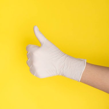Beyaz tıbbi eldivenli bir cerrahın eli onayını gösterir.