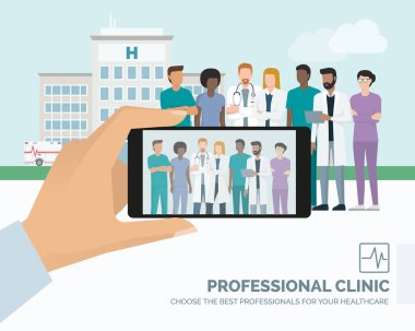 Profesyonel sağlık personeli ve birlikte poz hastanede Doktor, bir adam bir smartphone kullanarak resim alıyor