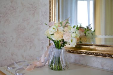 Beyaz güzel düğün buketi aynanın yanında duruyor. Ayna yansıması.