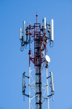 Mavi gökyüzü kış mevsiminde bulutludur ve anten ön plandadır..