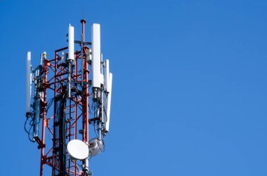 Mavi gökyüzü kış mevsiminde bulutludur ve anten ön plandadır..