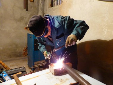 Kaynakçı metal bir yapı üzerinde çalışıyor.