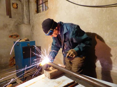 Kaynakçı metal bir yapı üzerinde çalışıyor.