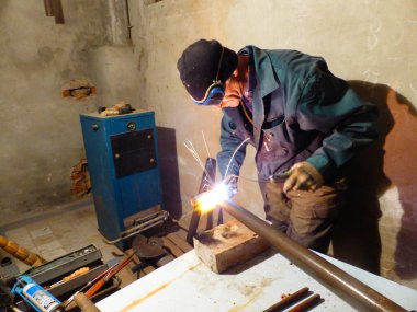 Kaynakçı metal bir yapı üzerinde çalışıyor.