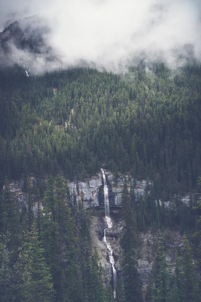 何に沿って多くの滝の つは氷河パークウェイの世界で最も風光明媚なドライブのいずれかです 低地の雲は この美しい滝にドラマを追加と思った ストック画像