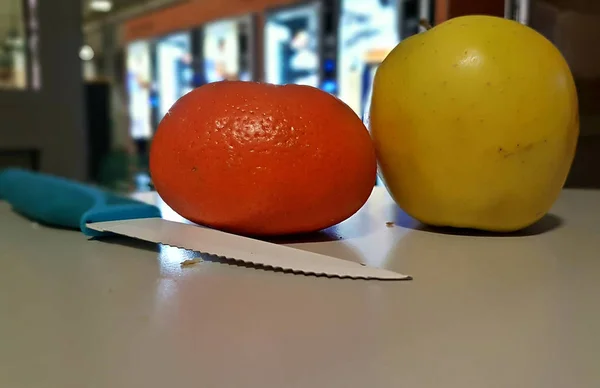 Ein Messer und eine Orange auf einem Tisch — Stockfoto