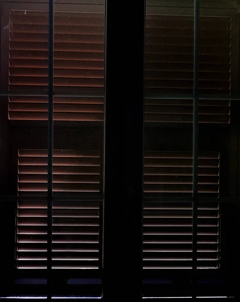 Luz que filtra entre as persianas fechadas — Fotografia de Stock