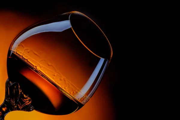 Glass of cognac close up in front of dark gradient background — Stock Photo, Image