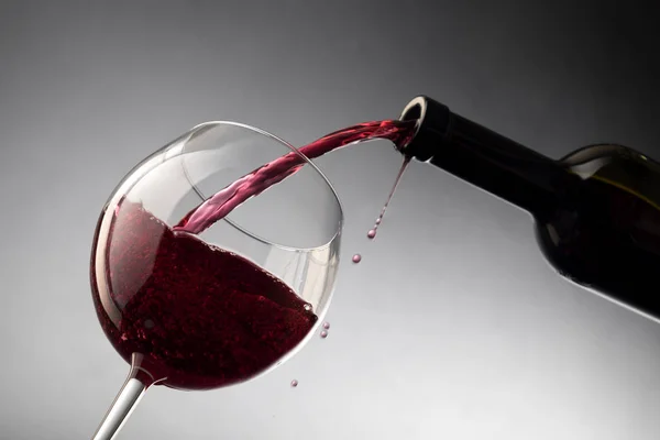 Hälla rött vin från flaska till vinglas — Stockfoto