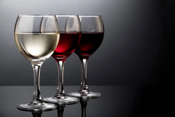 Eleganta röda, rosa och vitt vin glas i en svart bakgrund — Stockfoto