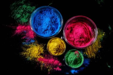 Hint Holi festival renkler koyu arka plan üzerinde dört kase.