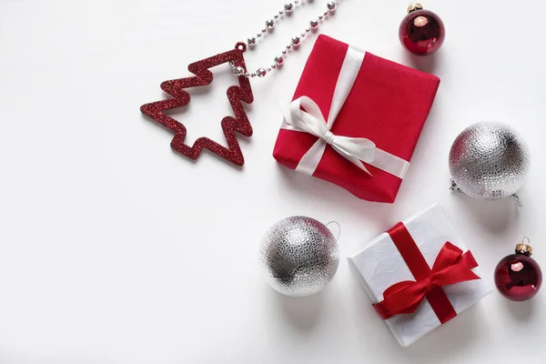 Año nuevo o Feliz Navidad tarjeta de felicitación sobre fondo blanco. Cajas de regalo, cintas, bolas de año nuevo . — Foto de Stock