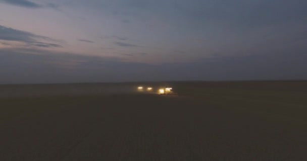 Вид с воздуха. Combine Night Harvester собирает урожай пшеницы — стоковое видео