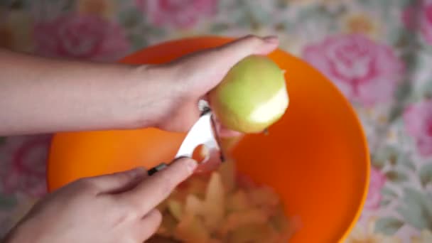 Женщина чистит яблоко на кухне — стоковое видео