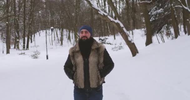 Joven guapo paseos invierno parque — Vídeo de stock