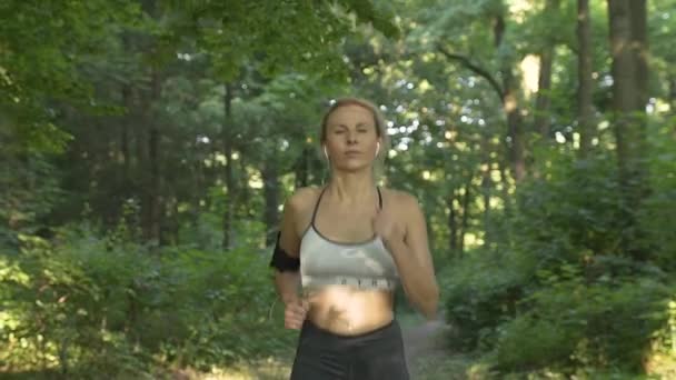 森の中の道を走っている女性 — ストック動画