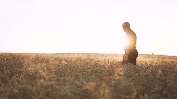 Homem caminhando através do campo de trigo — Vídeo de Stock