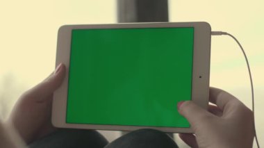 Bir tablet yeşil bir ekran ile tutan kız