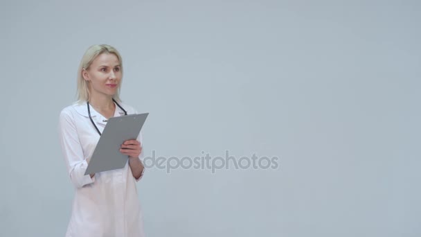 Jonge vrouwelijke arts in de witte kamer schrijven — Stockvideo