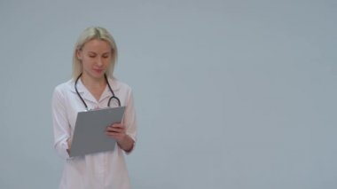 Beyaz önlük ve gülümseyerek kameraya seyir stetoskop ile kadın doktor portresi