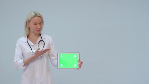 Portret van een vrouwelijke arts met witte jas en tablet met groen scherm — Stockvideo