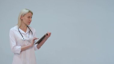 Tablette yazarak metin mutlu ve gülümseyen genç doktor.