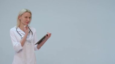 Tablette yazarak metin mutlu ve gülümseyen genç doktor.