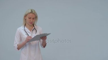 Beyaz önlük ve gülümseyerek kameraya seyir stetoskop ile kadın doktor portresi