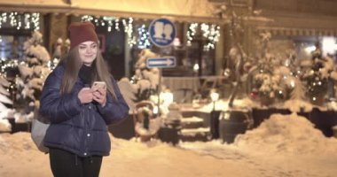Sırasında cep telefonu yürüyerek gece şehirde sokaklar kullanan kadın