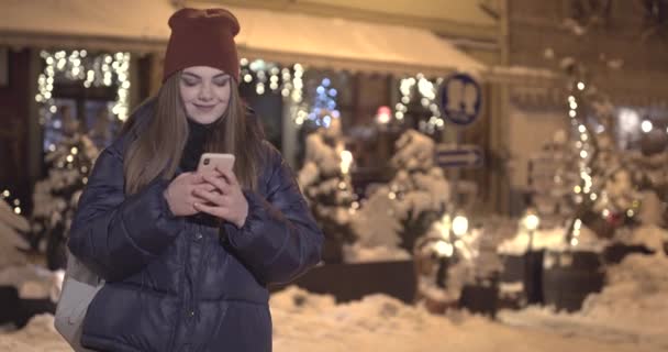 Mujer atractiva usando el teléfono móvil durante el paseo por las calles — Vídeos de Stock