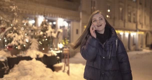 여자는 미소 하 고 거리에 도보 동안 휴대 전화에 대 한 이야기 — 비디오