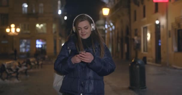 Mujer usando teléfono móvil durante un paseo por las calles — Vídeo de stock