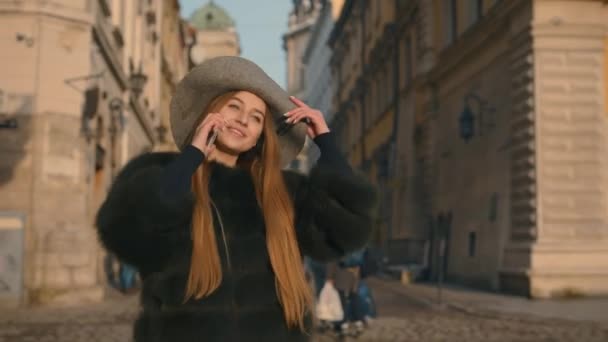 Chica joven llamando a alguien por teléfono, hablando y sonriendo felizmente — Vídeo de stock