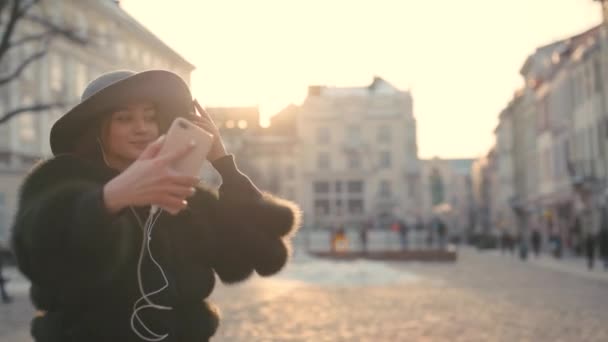 Жінка фотографує селфі зі смартфоном у місті — стокове відео