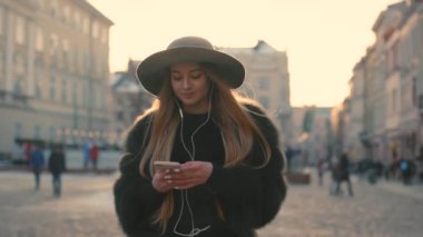 Şehir ve telefonda müzik dinlemek genç kız