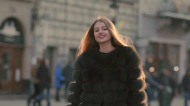 Kamera ve gülümsüyor için çekici kız büyük mavi gözleri ve şık bir görünüm ile döner