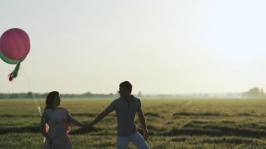 Bir alanda yürüyüş ve gün batımında elele çift. Ağır çekimde filme.