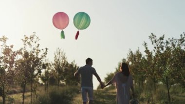 Çift bir elma bahçesinde yürüyüş ve güneş doğarken elele