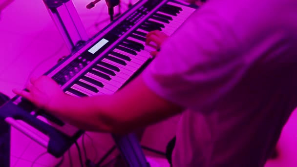 Manos tocando el piano. Dedos en el piano, luces de colores — Vídeos de Stock