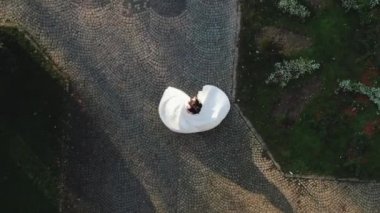 Güzel damat ve gelin. Havadan bakan damat, güzel gelinini kollarında sarıyor. Mutlu genç damat düğün gününde gelinini kollarında tutuyor.