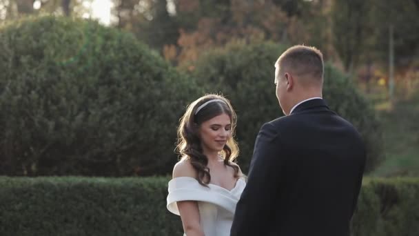 Pareja de boda a pie. Hermosa pareja joven acaba de entrar de la iglesia — Vídeos de Stock