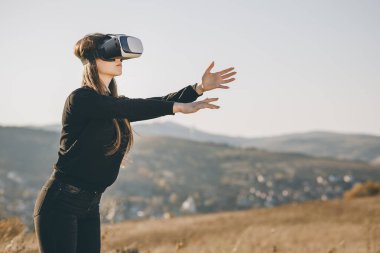 Sanal gerçeklik kulaklığı kullanan ve interaktif teknoloji sergisinde etrafa bakan kadın. VR, artırılmış gerçeklik, dijital sanat, fütüristik, interaktif, sürükleyici ve eğlence konsepti