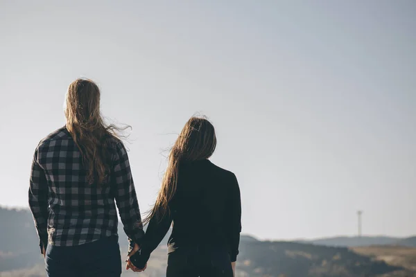 Romantisches Paar bei Sonnenuntergang Händchen haltend. Konzept von Liebe und Glück. Hände zusammengehalten mit Sonnenlicht flackern im Hintergrund — Stockfoto