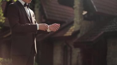 Takım elbiseli, şık, beyaz yaka ceketli bir genç. Pozitif adam giysilerini giyer ve sabah işe giderken giydiği elbiseyi kontrol eder..