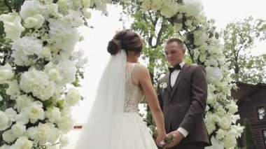 Gelin ve damat evlilik yeminleri için el ele tutuşuyorlar. Gelin nikah töreninde damada yemin ettiğini söylüyor..